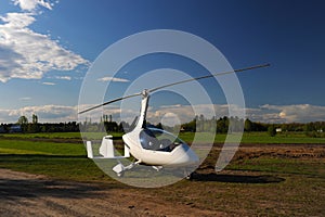 White gyroplane parked on the private airfield photo