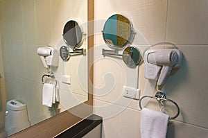 White Hair Dryer and mirror on wall in bathroom