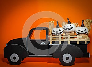 white Halloween Jack O\' Lantern pumpkins in back of black wooden pickup truck