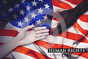 White hand and black hand with human right day text