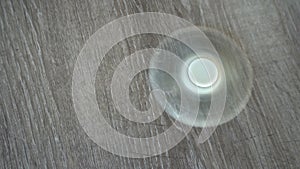 White hand spinner, or fidgeting spinner, rotating on the floor