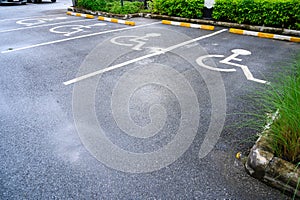 White handicapped symbol painted on asphalt floor special lane parking. Disabled parking spaces. traffic sign about handicaps