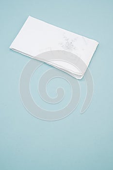 White handkerchief with a flower on it on a light blue background