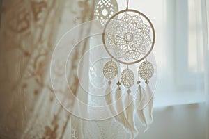 White handmade dreamcatcher in bedroom. Interior decoration. Beautiful dream catcher inside white room at home