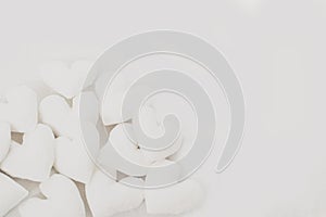 White handmade fabric hearts on white fabric background - image