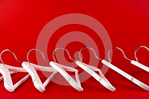 White hangers on a red background. Sales clothes concept