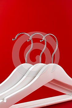 White hangers on a red background. Sales clothes concept