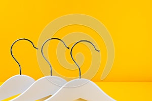 White hangers on a yellow background. Sales clothes concept