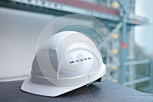 White hardhat, builder, architect helmet, work gloves on scaffolding, background of high buildings, protection inspecting at