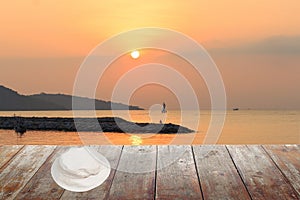 White hat on wood table in morning sunrise at sea