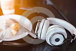 White headphone and coffee on table background.