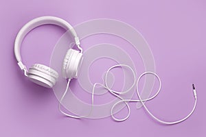 White headphone on purple background. Music concept.