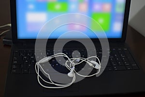 White headphones on the black laptop keyboard