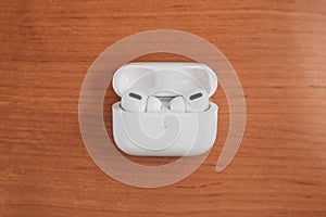 White headphones with box case on wood background