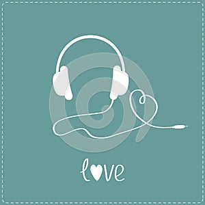 White headphones and cord in shape of heart. Blue background.