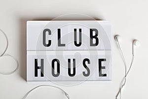 White headphones and lightbox with text clubhouse on white background