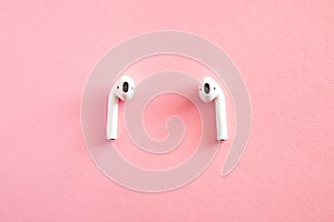 White headphones wireless earphones, copy space pink background