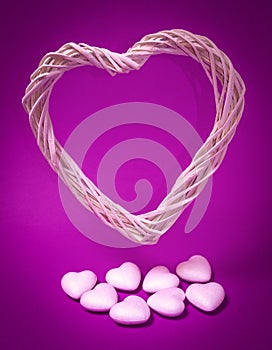 White heart made of wooden strips, below several smaller white hearts on a purple background. Romantic, Valentine`s Day, Mother`