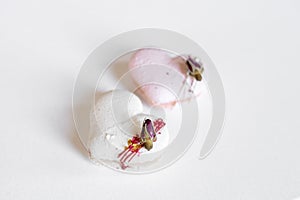 A white heart-shape cake lies on a white plate on a light background. Light macaroons. Delicious pastries