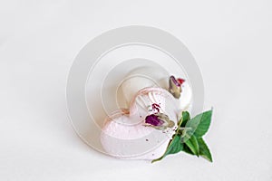 A white heart-shape cake lies on a white plate on a light background. Light macaroons. Delicious pastries