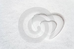 White heart shape in snow texture with a smaller white heart inside it - space for text