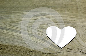 White heart on wooden background.
