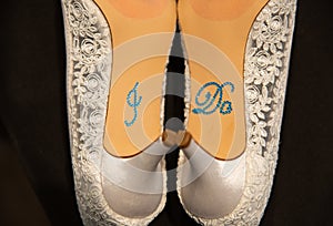 White heels with I do written on the bottom in blue