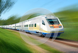 White high speed railway train runs on rail tracks among green trees. Train in motion. Motion blur