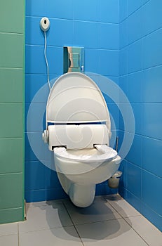 White high-tech ceramic toilet in tiled bathroom.