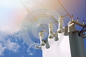 White high voltage transformer on blue sky background.