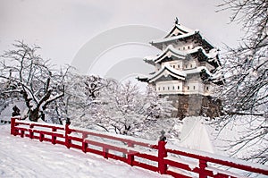 Hirosaki Castle and its red wooden bridge in winter season, Aomori, Tohoku, Japan photo