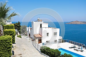 White holiday villas houses on resort with sea view and swimming pool and palm trees