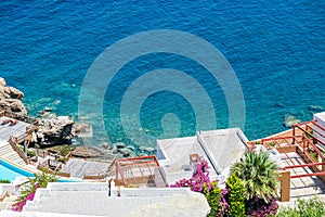 White holiday villas houses on resort with sea view and swimming pool and palm trees