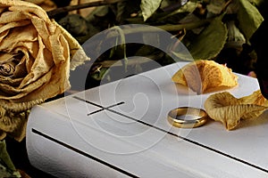 White Holy Bible, one wedding ring and dry yellow rose