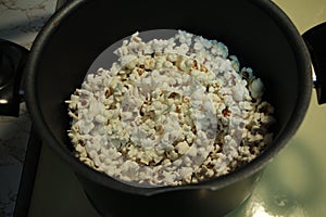 White homemade unseasoned popcorn, in black pot, shot from top.