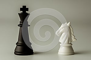 White horse chess and  black king chess stand encounter on a chessboard. - Business winner and fight concept