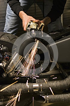 White hot metal sparks from grinder bouncing off bike frame