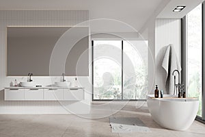 White hotel bathroom interior with bathtub, double sink and panoramic window