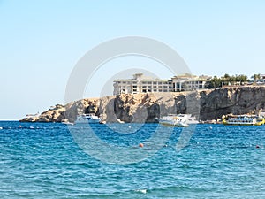 White hotel on the rocky shore of a beautiful sea. Rest in Egypt