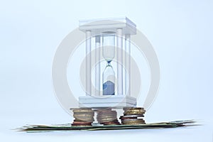 White hourglass stand on coins