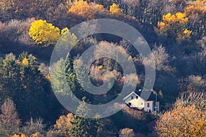 White house on a hillside amid colorful trees