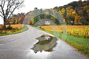 Blanco casa refleja en la lluvia charcos sobre el carreteras en rechazar 