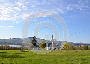 white house with river and green grass or lawn
