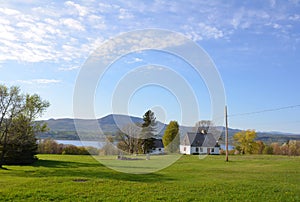 white house with river and green grass or lawn