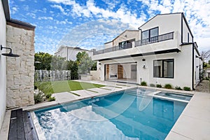 a white house with a swimming pool in the front yard