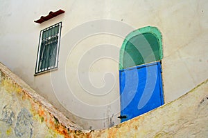 White house wall, facade, with blue door, window with grilles, island of ischia, campania, italy