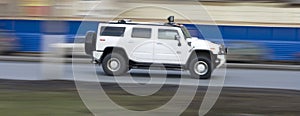 White huge hummer suv car driving fast, rushing forward