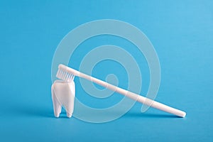 White human tooth model with toothbrush on blue medical background. Dental health minimal  medical poster