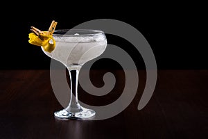 White iced cocktail in a glass glass on the leg