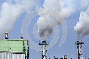 White industrial steam in factory on blue sky